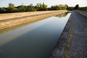 The Canal du Midi in Beziers at sunset, a long canal that connects the Atlantic Ocean with the Mediterranean Sea in Southern France. A world heritage site since 1996