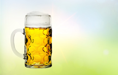 Maß Bier vor sonnigem Hintergrund