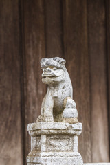 BAC NINH, VIETNAM - JULY 25, 2015 - Small statue at the entrance to But Thap Pagoda with a demon or lion on a decorated pedestal with a flower motif