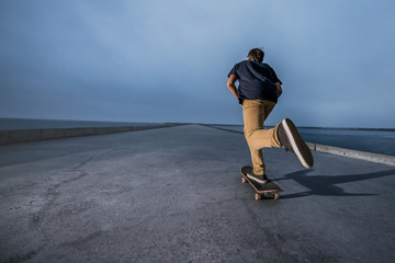 Skateboarder pushing on a concrete pavement