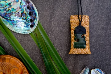 Photo sur Plexiglas Nouvelle-Zélande New Zealand - Maori themed objects - pounamu greenstone pendant with flax leaves and abalone shells