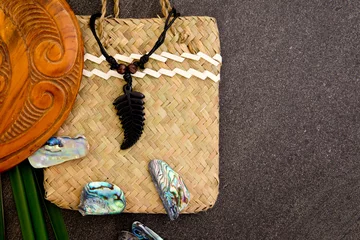 Poster New Zealand - Maori themed objects - fern leaf pendant, wooden mere with flax leaves and abalone shells © CreativeFire