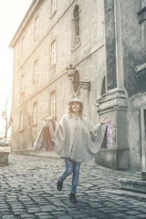 Fototapeta na wymiar Happy woman in shopping. Young woman walking on the street