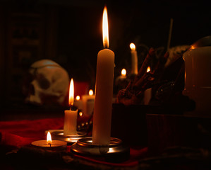Burning candles and human skull. Halloween and occult concept.