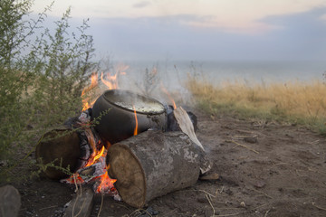 Cook at the Stake in the morning at a cliff with a sea view
