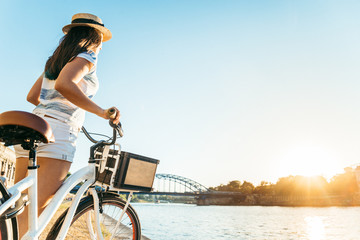 woman take a rest at embankment of the river and looking on sunset