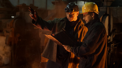 Engineer and Worker Have Conversation in Foundry. Engineer Using Tablet. Rough Industrial...