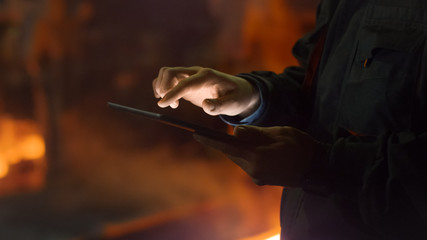 Engineer in Glasses using Tablet PC in Foundry. Industrial Environment.