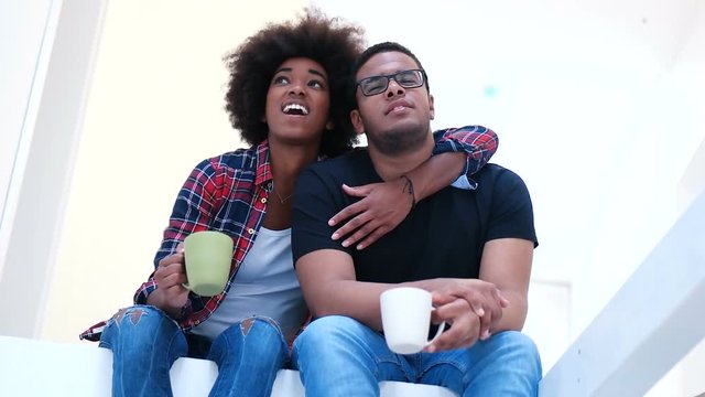 mixed race couple enjoying coffee after moving in new home