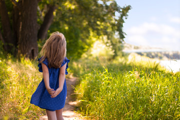 Naklejka na ściany i meble little girl goes on summer forest path