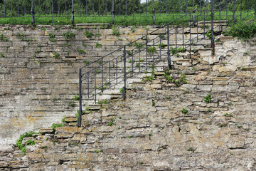 An old stone staircase with rails, descent to the water in a historical canal with a lock to pass...