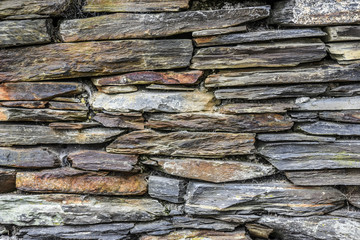 Stone wall made of various stones of different colors and shapes