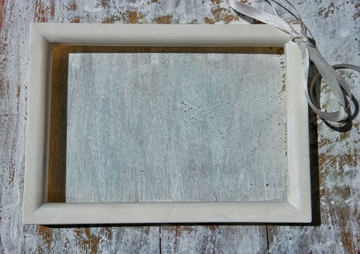 The white wooden fraime lying on a white wooden  plank 