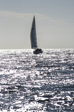 Sailboat sailing the sea on sail to the light.