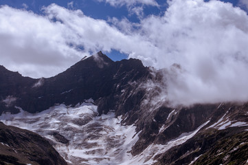 Wolken vor verschneiten Bergen