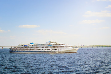 A three-deck motor ship floats along the river.