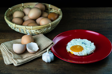 Fried egg with egg shell with garlic and eggs in the basket on the wooden table