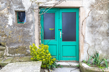 Fototapeta na wymiar Green entrance door to a house on stone street in Istria, Croatia, Europe.