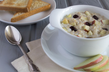 Breakfast with oatmeal and bread  toasts on the grey wooden background 
