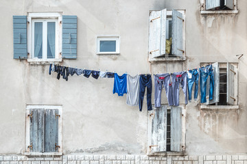 Men's washed laundry hanging on the windows of the facade of an old house in Rovinj town, Croatia, Europe.