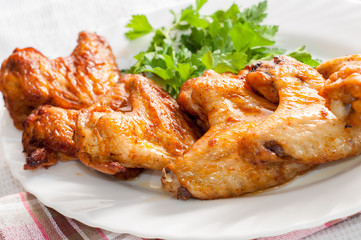 chicken wings with greens on the plate