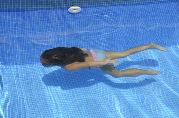 NIÑA NADA EN LA PISCINA