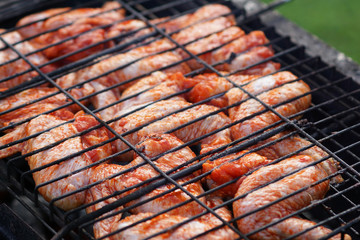 Grilling chicken wings on barbecue grill. 