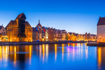Fototapeta premium Gdansk at night with historic port crane reflected in Motlawa river, Poland