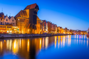 Fototapeta na wymiar Gdansk at night with historic port crane reflected in Motlawa river, Poland
