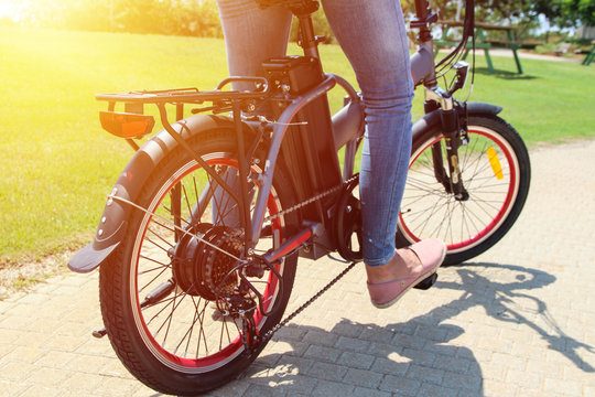 A woman on electric bicycle in a park