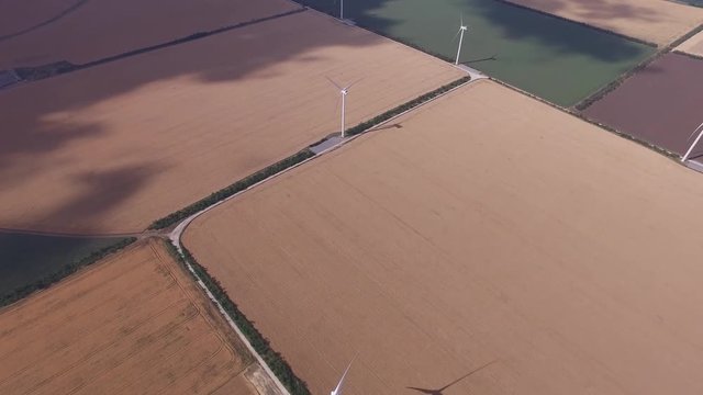 Windmills restorative bioenergy on the background of yellow and green fields. Aerial survey