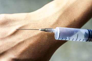 A hand giving painkiller injection.