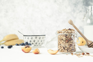 Granola in a jar with fruits and milk.