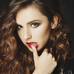 Fototapeta premium Beautiful young woman posing in black leather jacket over grey background. Fashion concept.