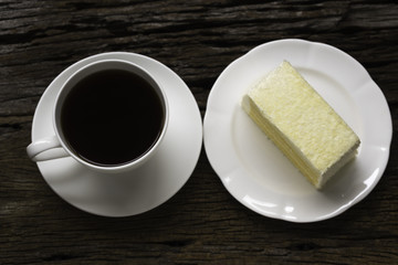A cup of coffee and a piece of coconut cake