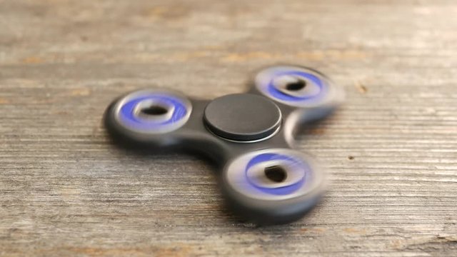 Popular fidget spinner spinning on rustic table