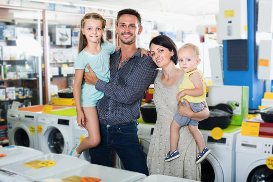 Happy family of four shopping electronics in household