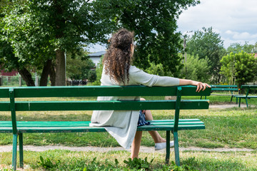 Young woman sitting on a bench in the park