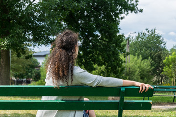 Young woman sitting on a bench in the park