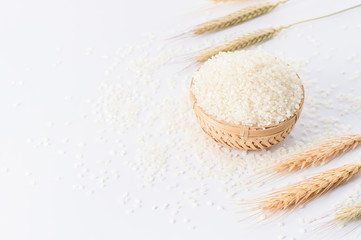 raw rice in a bamboo basket with wheat isolated on white background