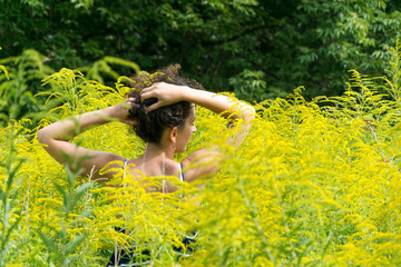 Young woman standing in yellow flowers field