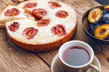 Pie with plum. In rustic style on a wooden surface