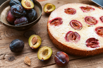 Pie with plum. In rustic style on a wooden surface