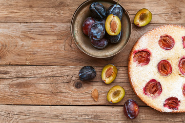 Pie with plum. In rustic style on a wooden surface