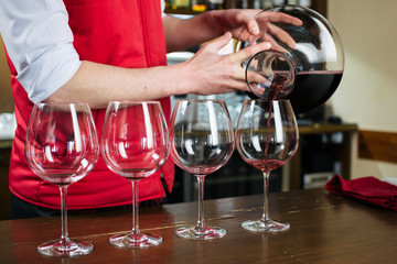 Sommelier filling glass with red wine in restaurant