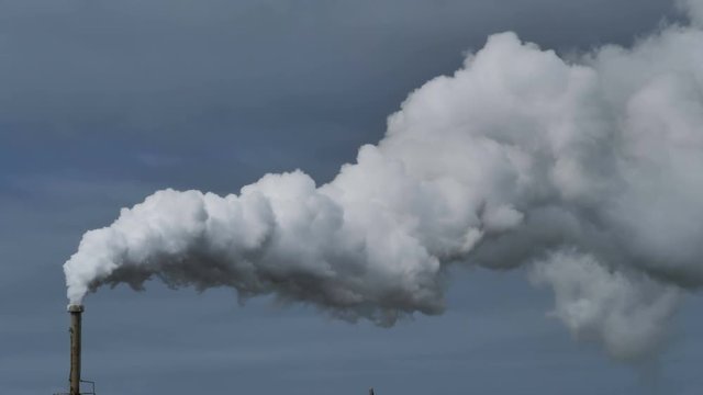 Billowing steam from smoke stack across sky 4k, slow motion wide
