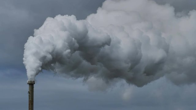 Billowing steam from smoke stack across sky 4k, slow motion