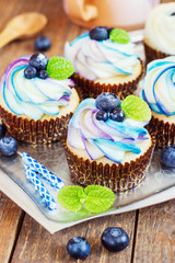 Gentle cupcake with cream and berries on a light background