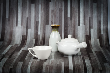 white tea pot and cup on wood