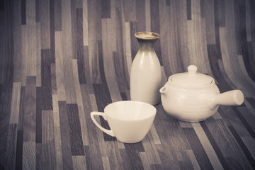 white tea pot and cup on wood